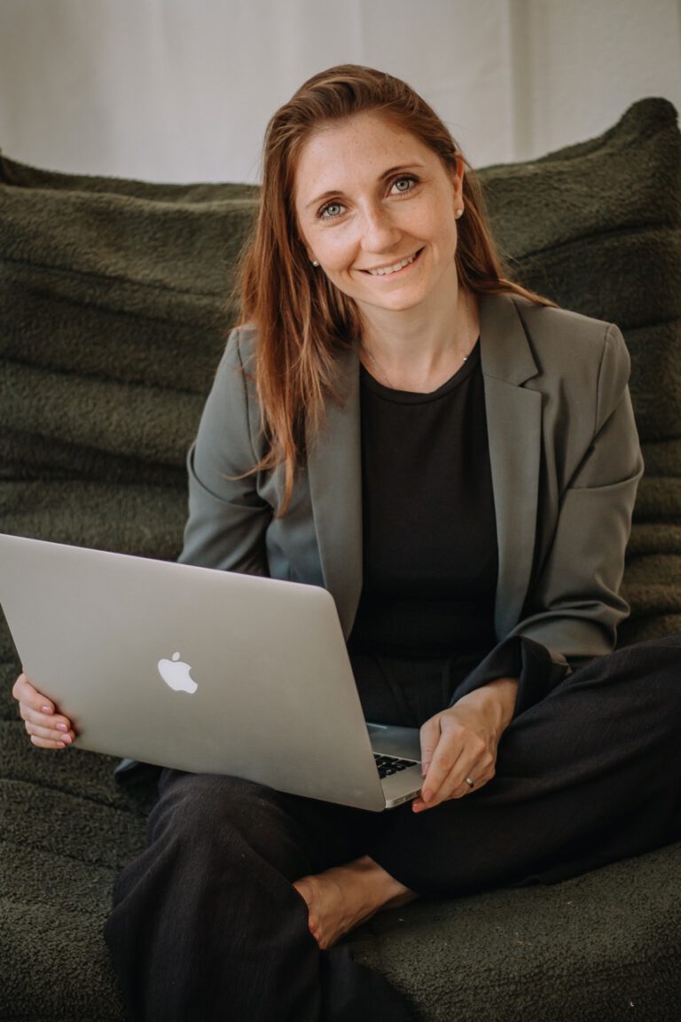 Frau mit grünem Blazer und Laptop